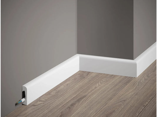 Plinthe décorative blanche MD004 installée au bas d’un mur gris avec sol en bois clair, idéale pour cacher les câbles.