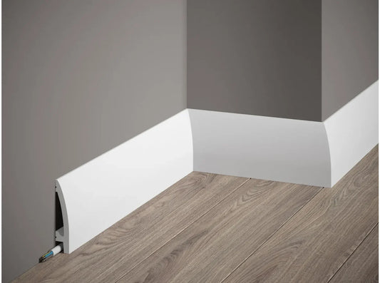 Plinthe décorative blanche MD017 installée le long d’un mur gris avec parquet bois clair, intégrant un canal pour câbles.