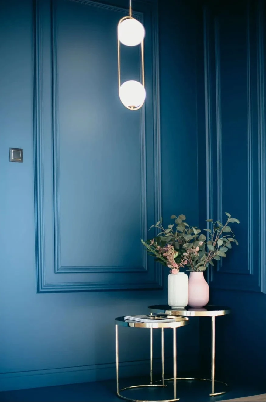 Mur bleu avec moulures décoratives et plinthe blanche MD356 pour une décoration intérieure élégante et contemporaine.