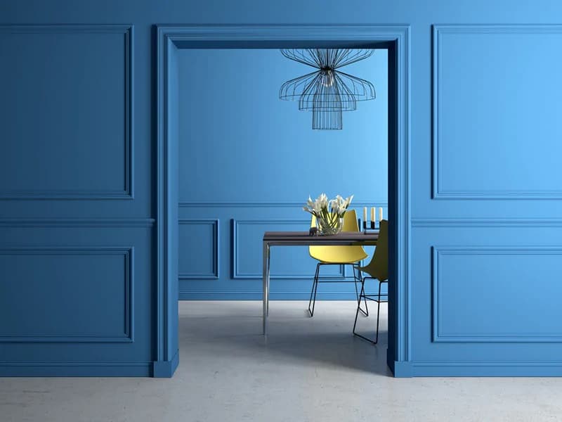 Intérieur moderne bleu avec moulures murales décoratives et plinthe MD009 blanche pour une finition élégante et haut de gamme.