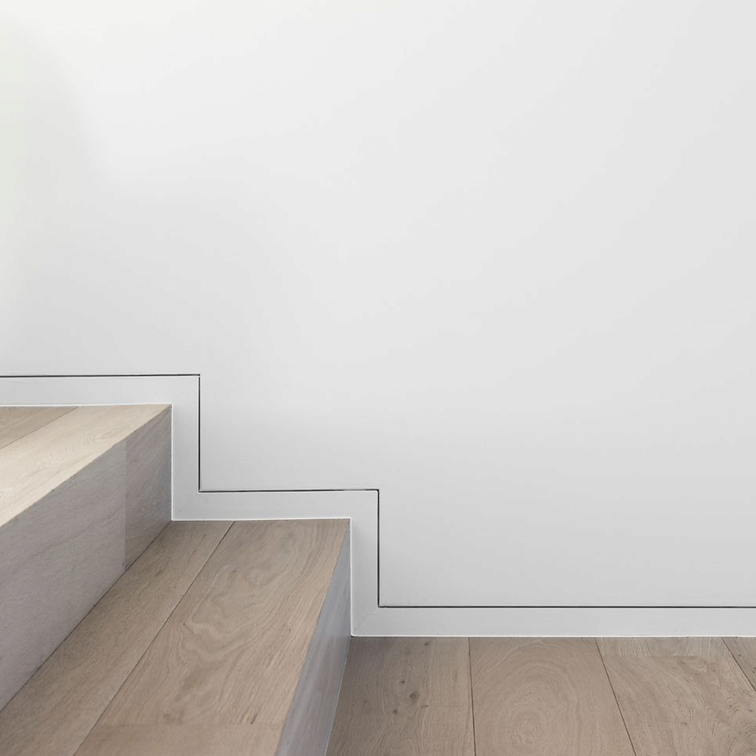 Plinthe invisible affleurante installée sur mur d’escalier, finition minimaliste avec profilé S1060.