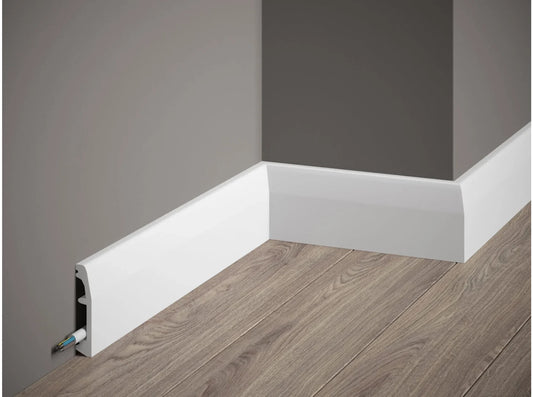 Plinthe décorative blanche MD017 200x6,9x1,4 cm avec cache-câble intégrée posée sur mur gris et sol effet bois Plinthe décorative blanche MD017 200x6,9x1,4 cm avec cache-câble intégrée posée sur mur gris et sol effet bois