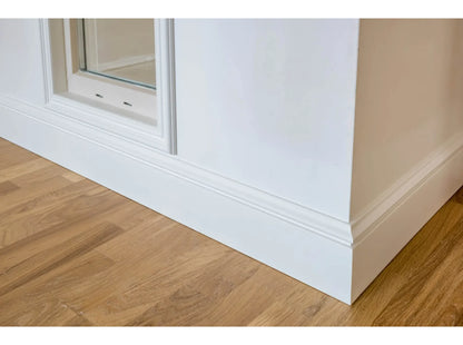Plinthe décorative MD358 blanche posée sous une fenêtre avec parquet bois – finition soignée et classique