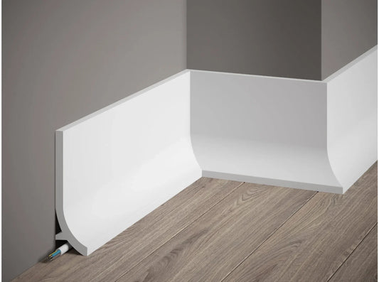 Plinthe décorative QS011 blanche à bord arrondi avec passage de câbles, installée sur mur gris et sol effet bois – dimensions 200 x 13,5 x 4 cm